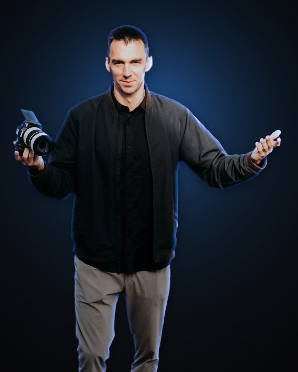 Andrew Rusk holding a Canon camera with a white telephoto lens